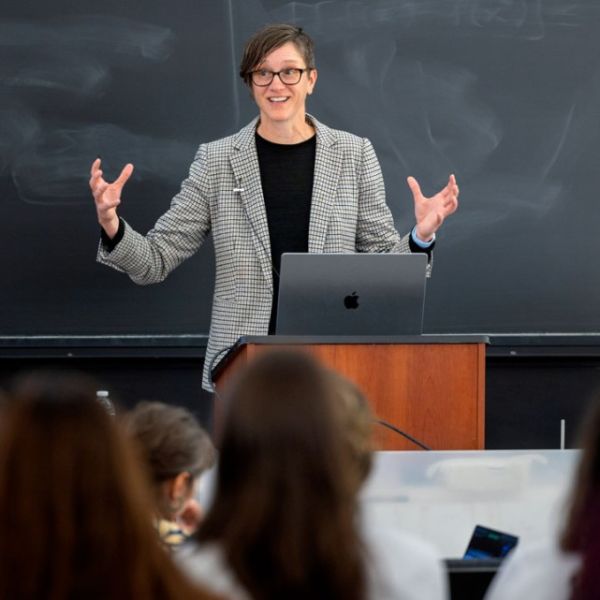 A color photo of a woman giving a presentation