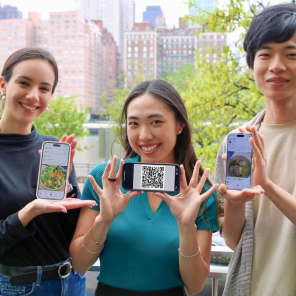 Provided Alexandra Taic M.B.A. '25 (left), Selina Li ’25 and Zach Zhong ’25, all principals of Gymii.ai, a new nutrition tracking app, hold up the app and a recent QR code.