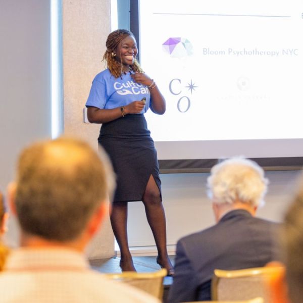 A color photo showing a woman giving a presentation