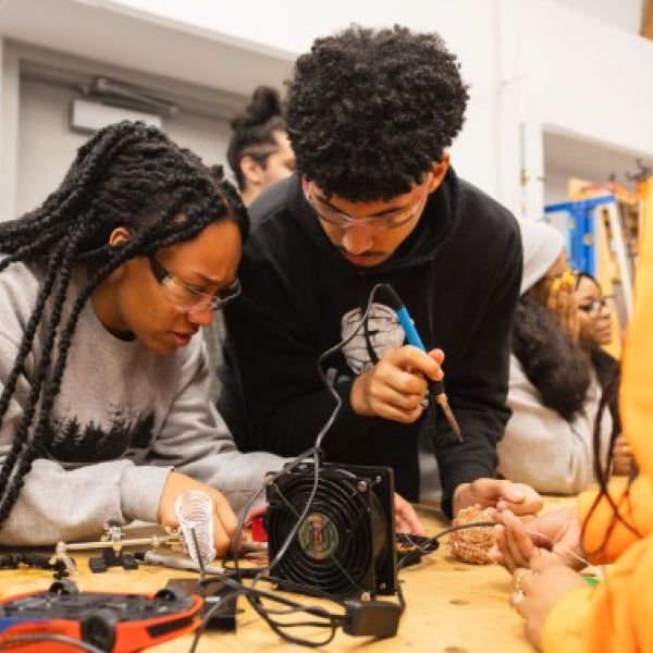 Jason Koski/Cornell University Students use a soldering iron to rewire a toy at one of many toy adapting sessions organized by the Big Red Adaptive Play and Design Initiative.