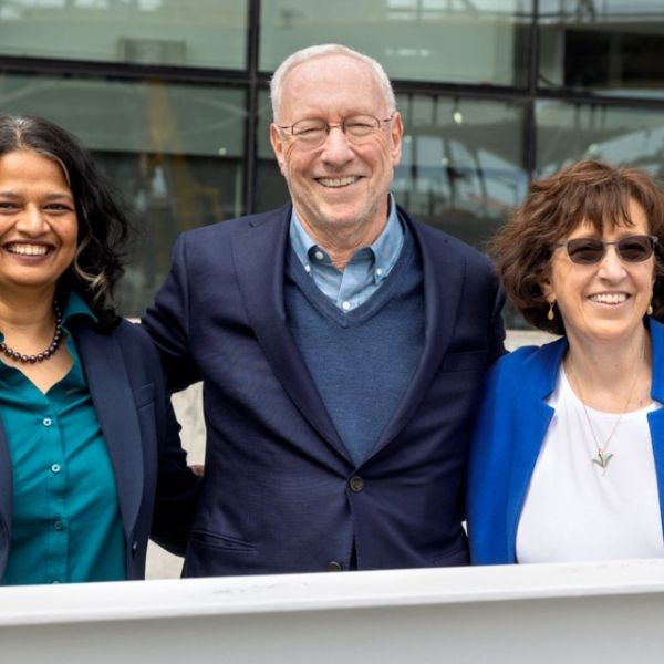 A color photo showing 3 people smiling for a photo