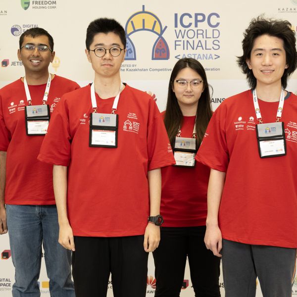 A color photo showing 4 people smiling for a photo at the ICPC World Finals