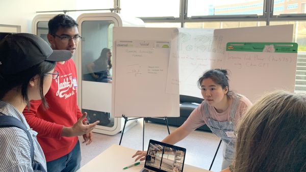 A color photo showing a man and woman presenting their project during ACSU Research Night.