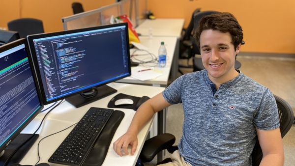 Benny Rubin A color photo of a man sitting and smiling for a photo