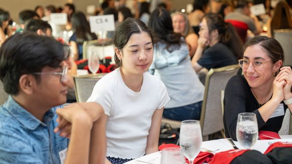 A color photo of three people talking at the new majors welcome for Cornell Bowers CIS.