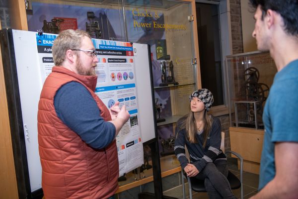 Caption: Michael Sack (left), a doctoral student in the field of information science, explains his team’s project called Enact, a platform to empower environmental literacy &amp; collective action to tackle climate change. Photos by Rachel Philipson