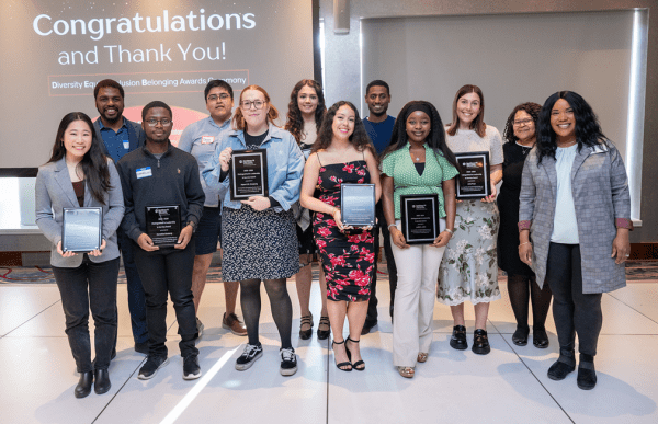 A color photo showing a group of award winners with their awards