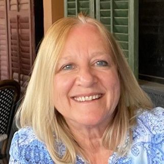 A color photo of a woman smiling for a photo