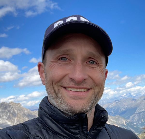 Alex Conway A color photo of a man smiling for a photo