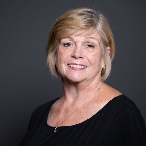 A color photo of a woman smiling for a photo