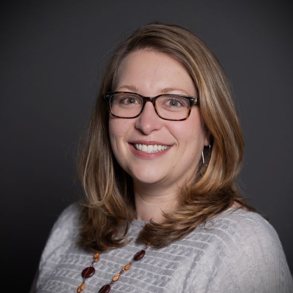 A color photo of a woman smiling for a photo