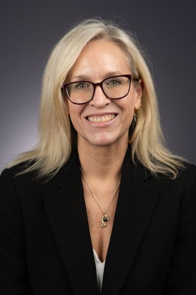 A color photo of a woman smiling for a photo