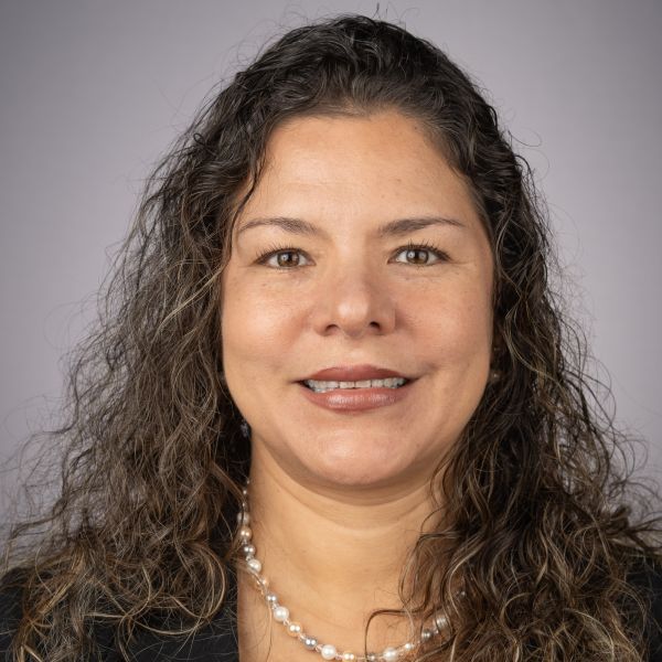 A color photo of a woman smiling for a photo