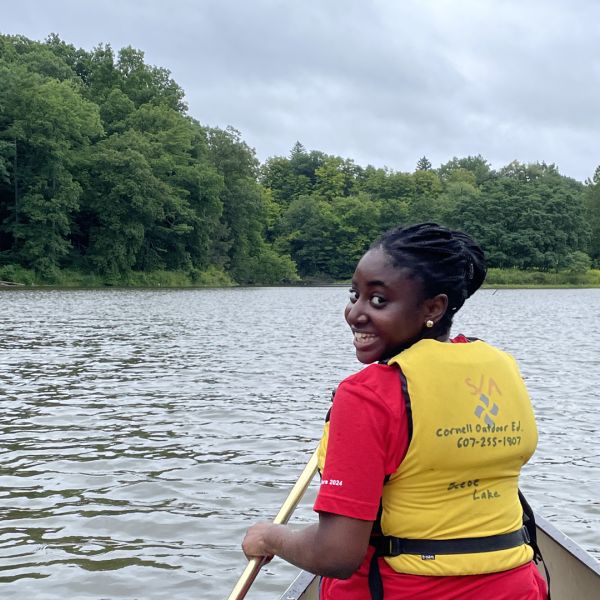 A color photo of a woman looking back while in a canoe