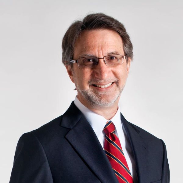 A color photo of a man wearing a suit and tie