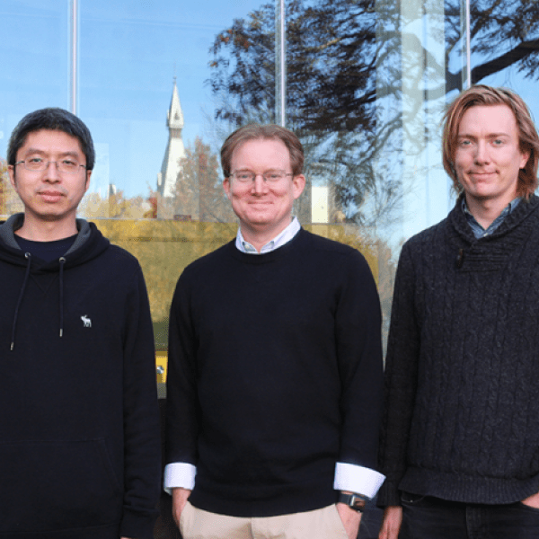 Three men stand outside