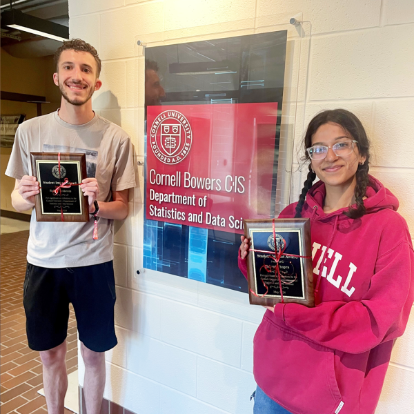 A color photo showing a man and a woman, both holding plaques