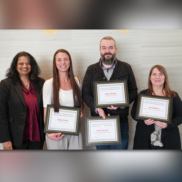 A color photo showing 3 women and 1 man. Some with awards